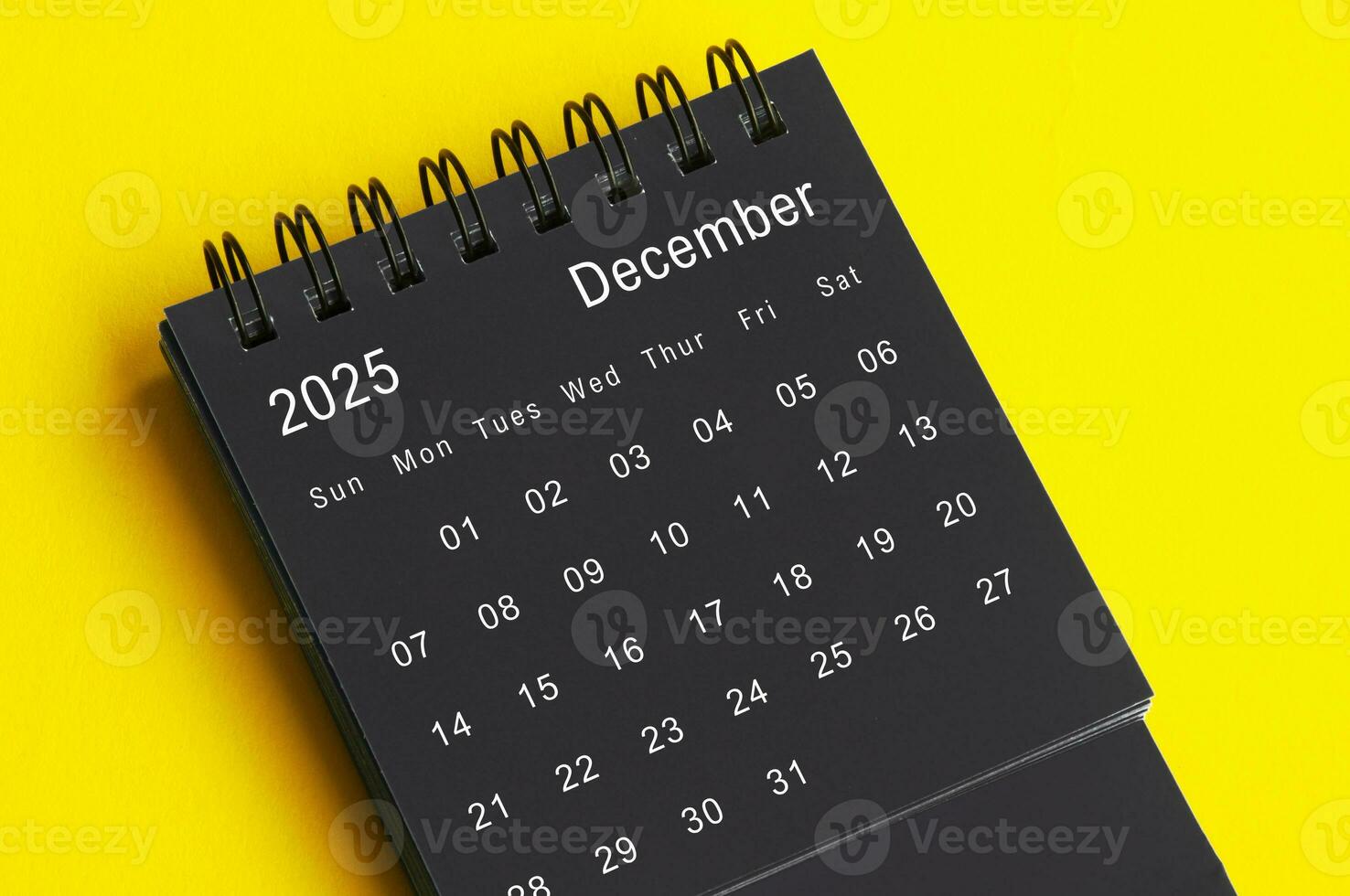Dezember 2025 schwarz und Weiß Schreibtisch Kalender auf Gelb Startseite Hintergrund. Kalender Konzept foto