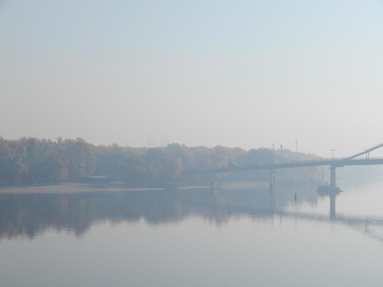 Panorama der Herbststadt im Nebelschleier über dem Fluss foto