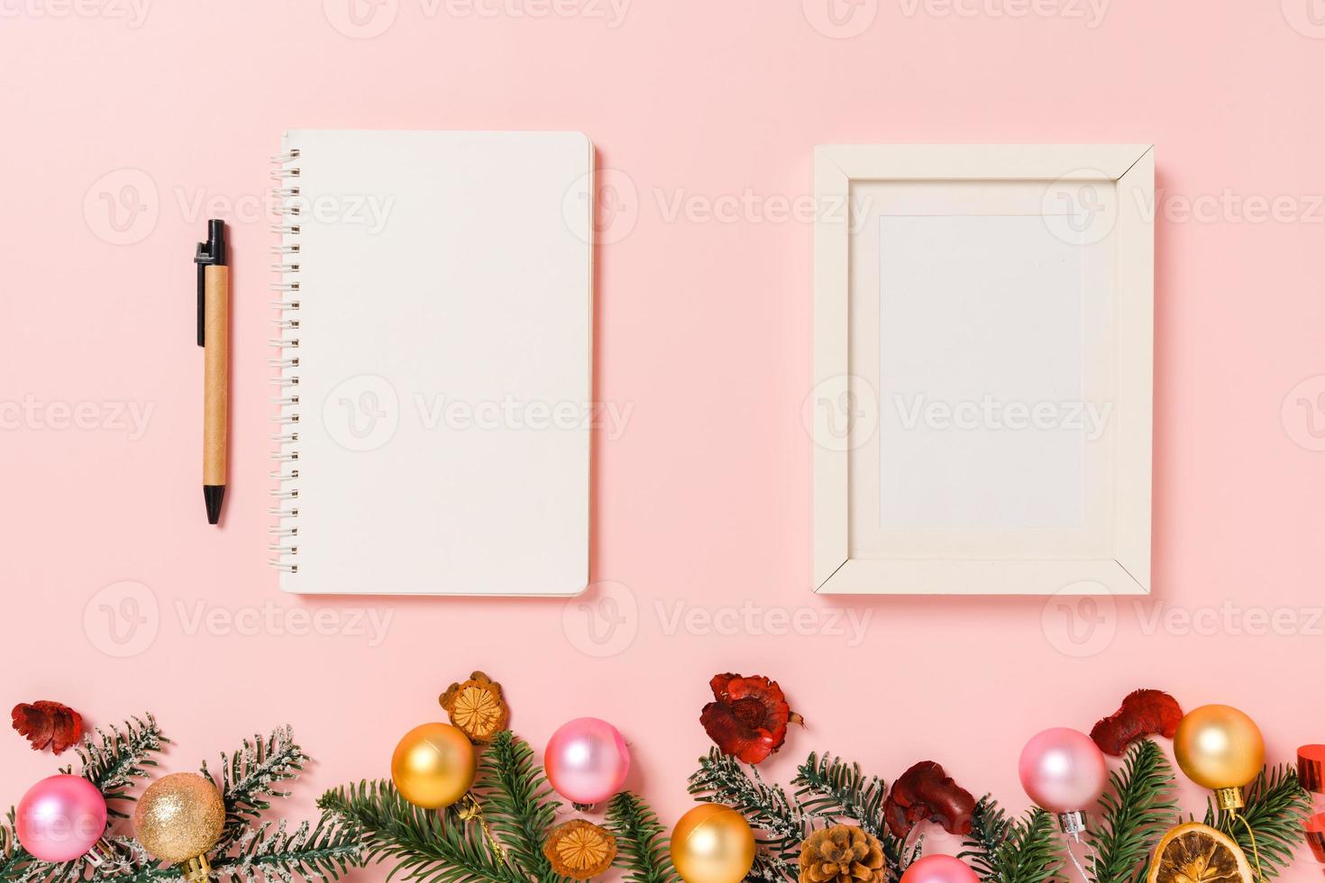 minimale kreative flache Lage der traditionellen Winterweihnachtskomposition und der Neujahrsferienzeit. Ansicht von oben offenes Mockup schwarzes Notizbuch für Text auf rosa Hintergrund. Mock-up und kopieren Sie Raumfotografie. foto