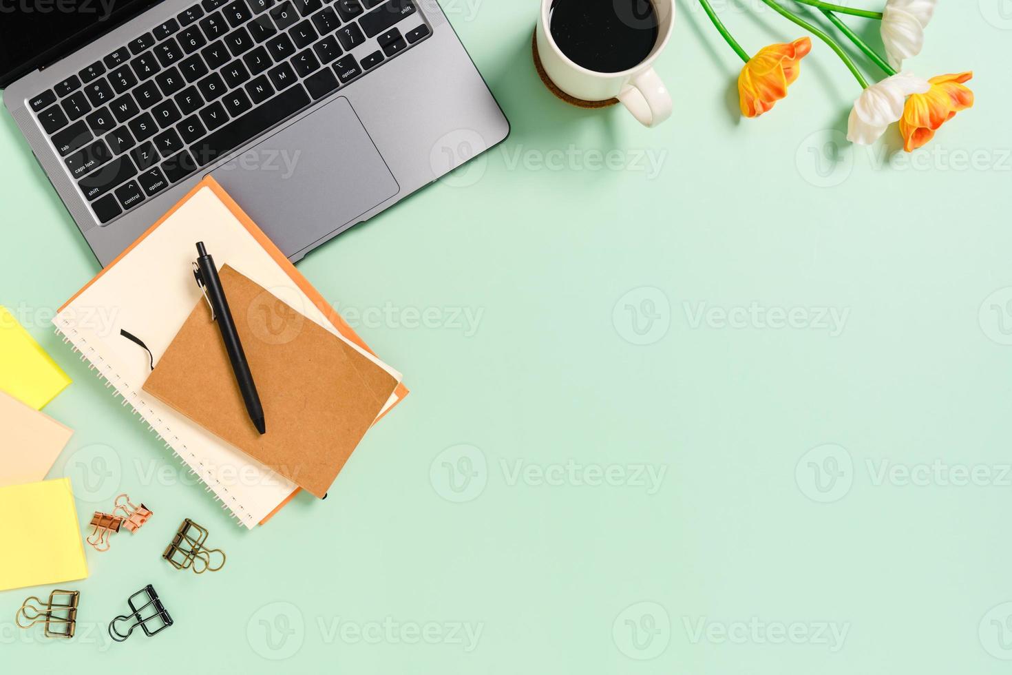 minimaler arbeitsplatz - kreatives flaches foto des arbeitsplatzes. Schreibtisch von oben mit Laptop, Kaffeetasse und Notizbuch auf pastellgrünem Hintergrund. Draufsicht mit Kopienraumfotografie.