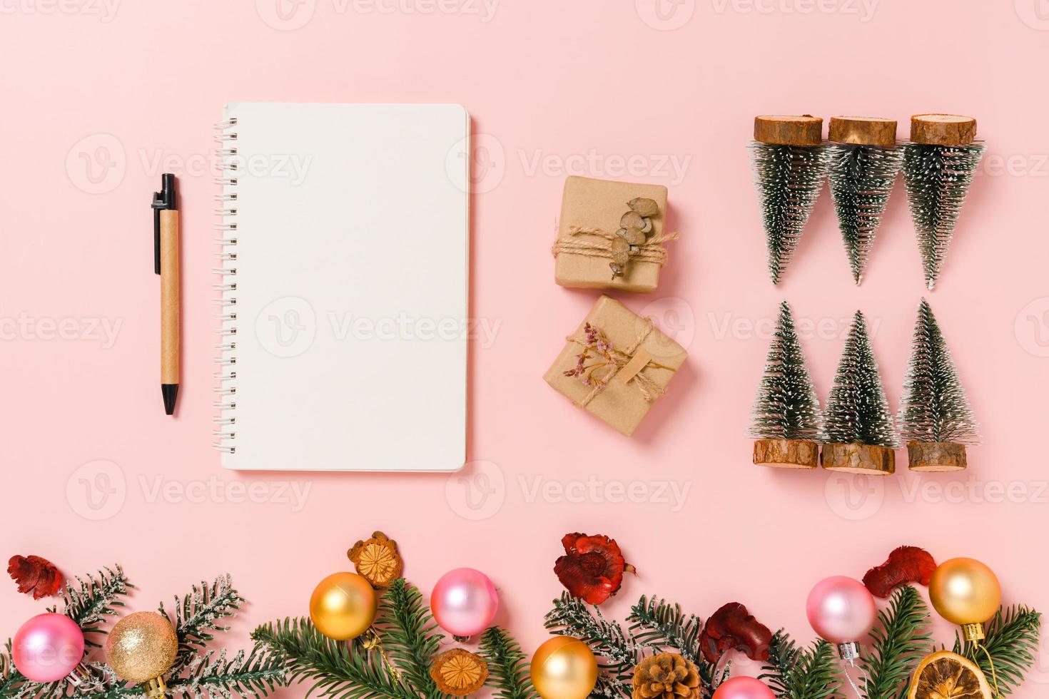 minimale kreative flache Lage der traditionellen Winterweihnachtskomposition und der Neujahrsferienzeit. Ansicht von oben offenes Mockup schwarzes Notizbuch für Text auf rosa Hintergrund. Mock-up und kopieren Sie Raumfotografie. foto