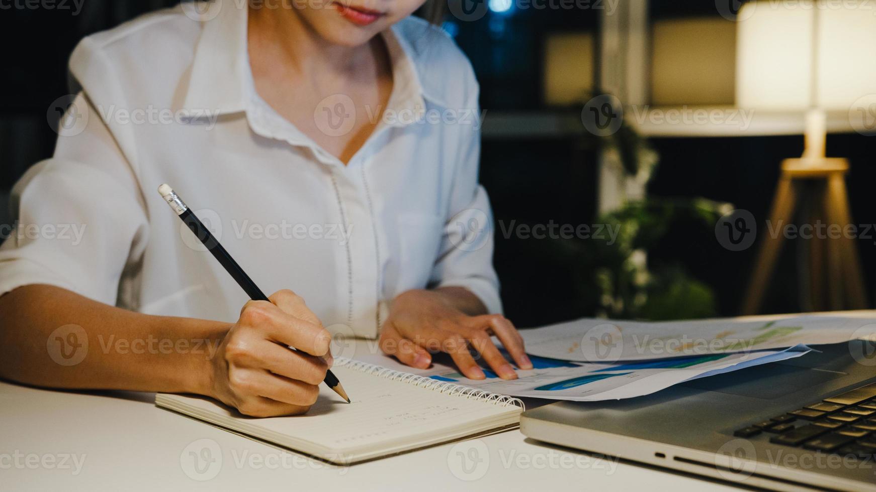 freiberufliche asiatische Dame mit Laptop-Hartarbeit im Wohnzimmer im Haus. Nachtarbeit von zu Hause aus Überlastung, Fernarbeit, Selbstisolation, soziale Distanzierung, Quarantäne zur Vorbeugung von Coronaviren. foto