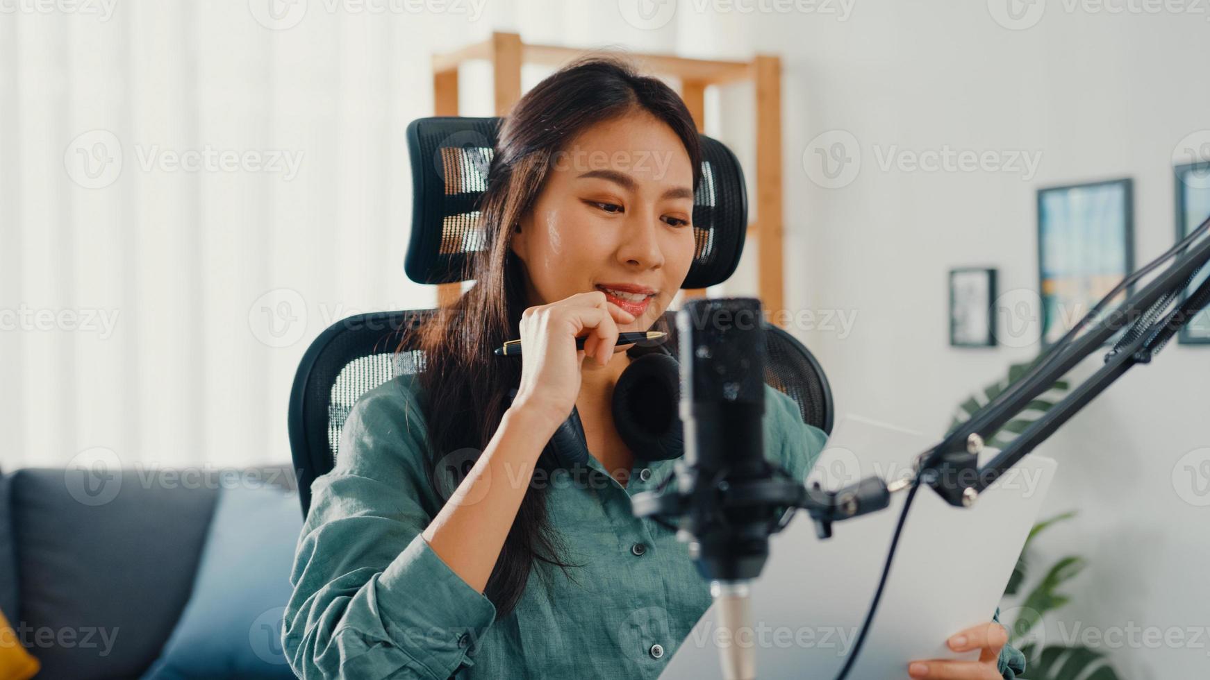 Attraktiver Asien-Mädchen-Rekord-Podcast verwendet Mikrofon-Haltepapier, um Inhalte für Audio-Blog-Gespräche zu erstellen und für das Überprüfungsthema in ihrem Zimmer zu üben. Audio-Podcast von zu Hause aus machen, Sound-Equipment-Konzept. foto