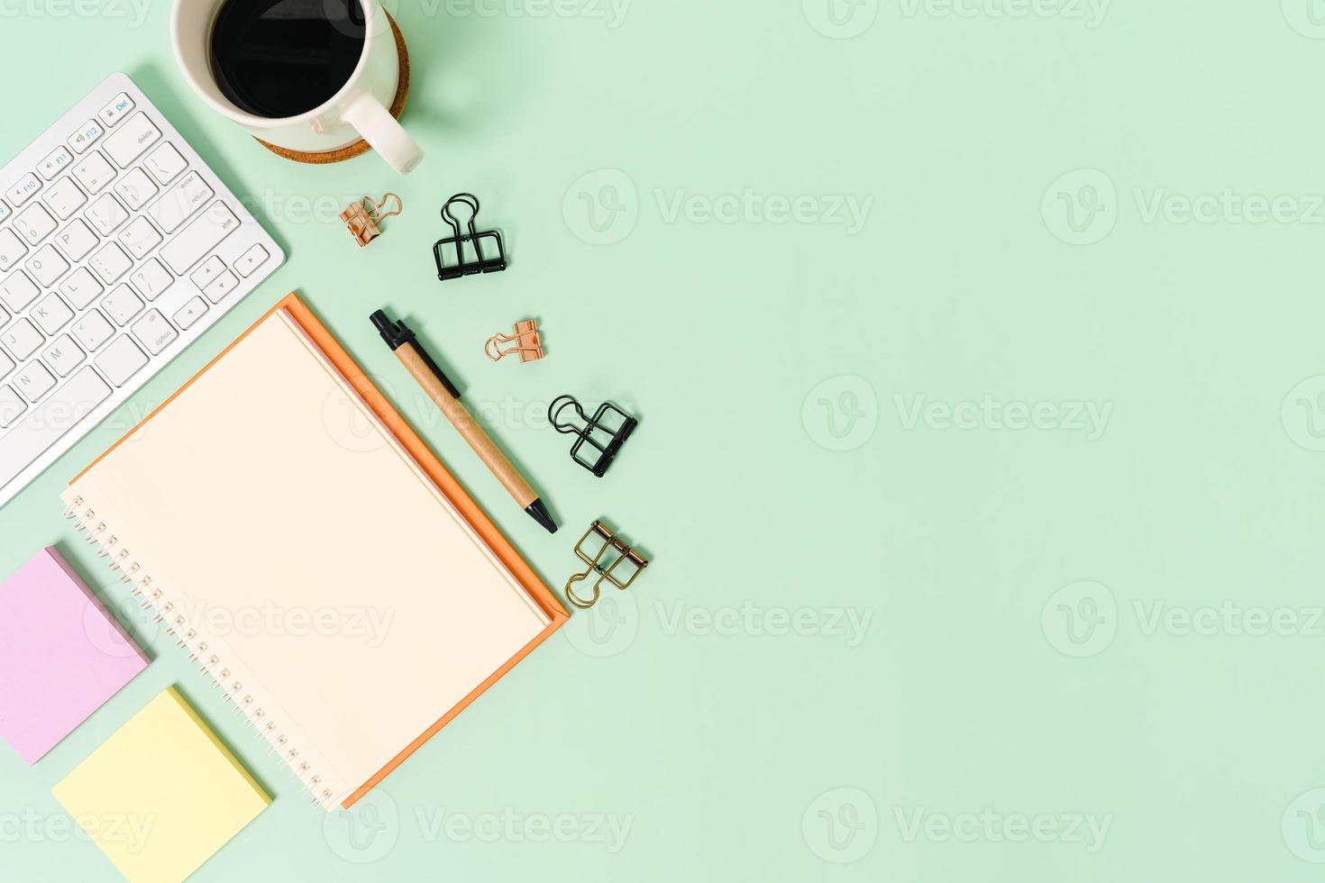 kreatives flaches Laienfoto des Arbeitsplatzschreibtisches. Schreibtisch von oben mit Tastatur und offenem Mockup-Schwarz-Notizbuch auf pastellgrünem Hintergrund. Draufsichtmodell mit Kopienraumfotografie. foto