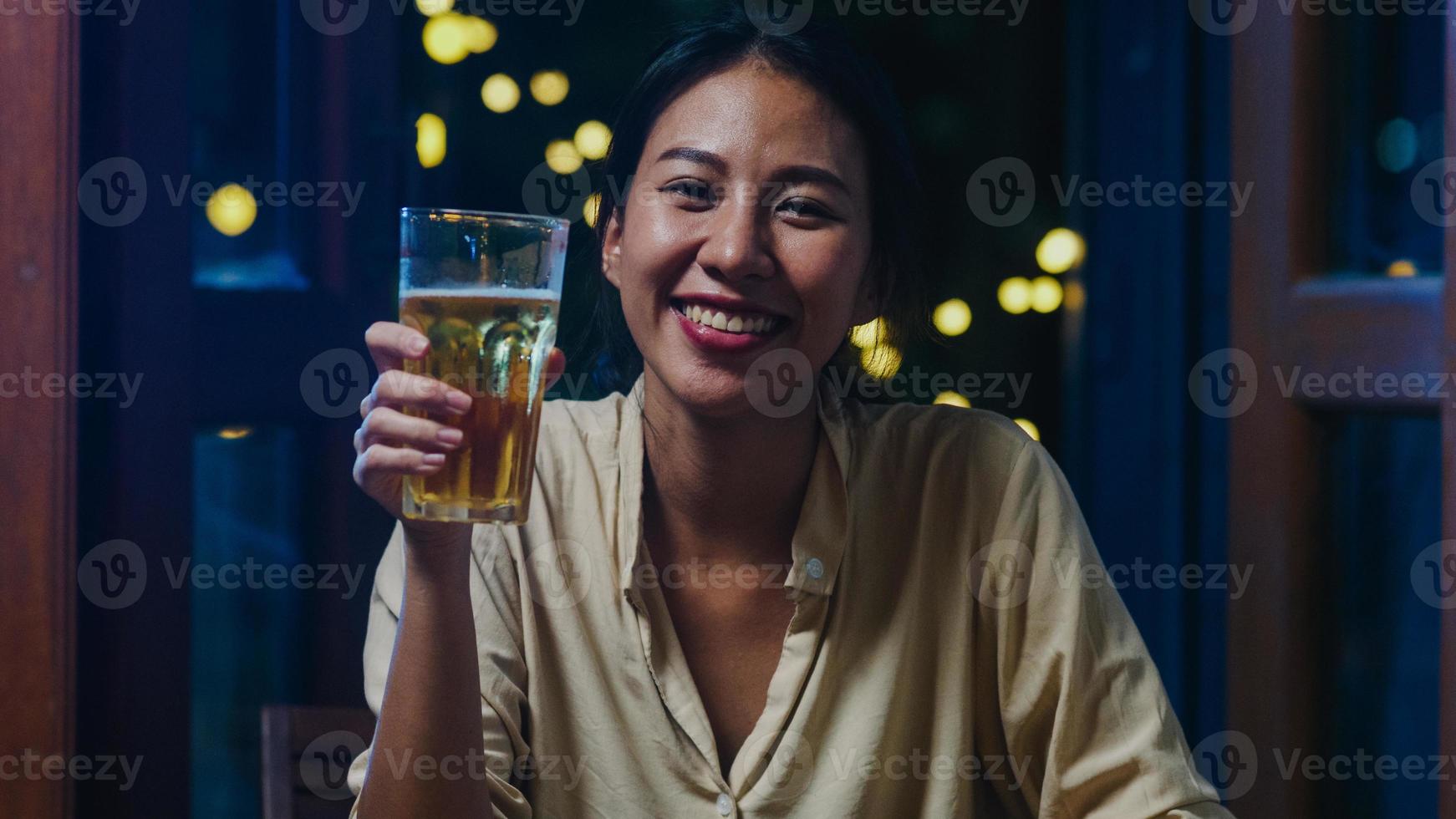 junge asiatische dame trinkt bier und hat spaß fröhliche nacht party neujahrsveranstaltung online feier per videoanruf per telefon zu hause nachts. soziale Distanz, Quarantäne für Coronavirus. Standpunkt oder Standpunkt foto