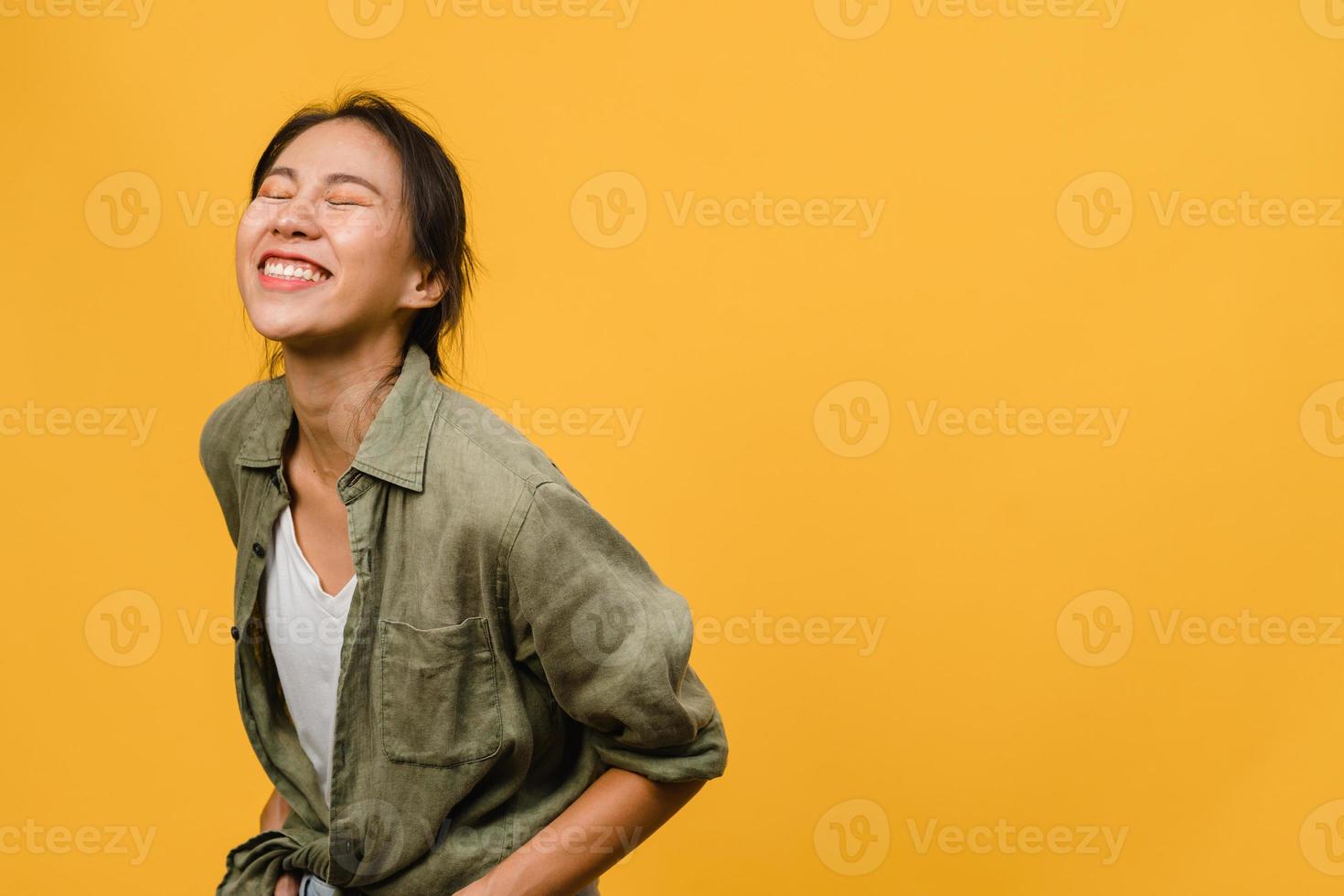 Porträt der jungen asiatischen Dame mit positivem Ausdruck, breit lächeln, in Freizeitkleidung auf gelbem Hintergrund gekleidet. glückliche entzückende frohe frau freut sich über erfolg. Gesichtsausdruck Konzept. foto