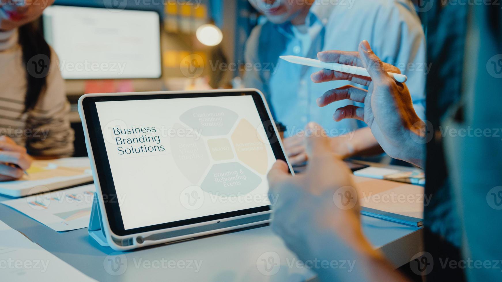 Asien-Geschäftsleute treffen Plananalyse-Statistiken Brainstorming und Header des Teams halten Tablet-Punkt-Diagramm und Mitarbeiter nehmen in der modernen Home-Office-Nacht zur Kenntnis. Erfolgskonzept der Finanzstrategie. foto