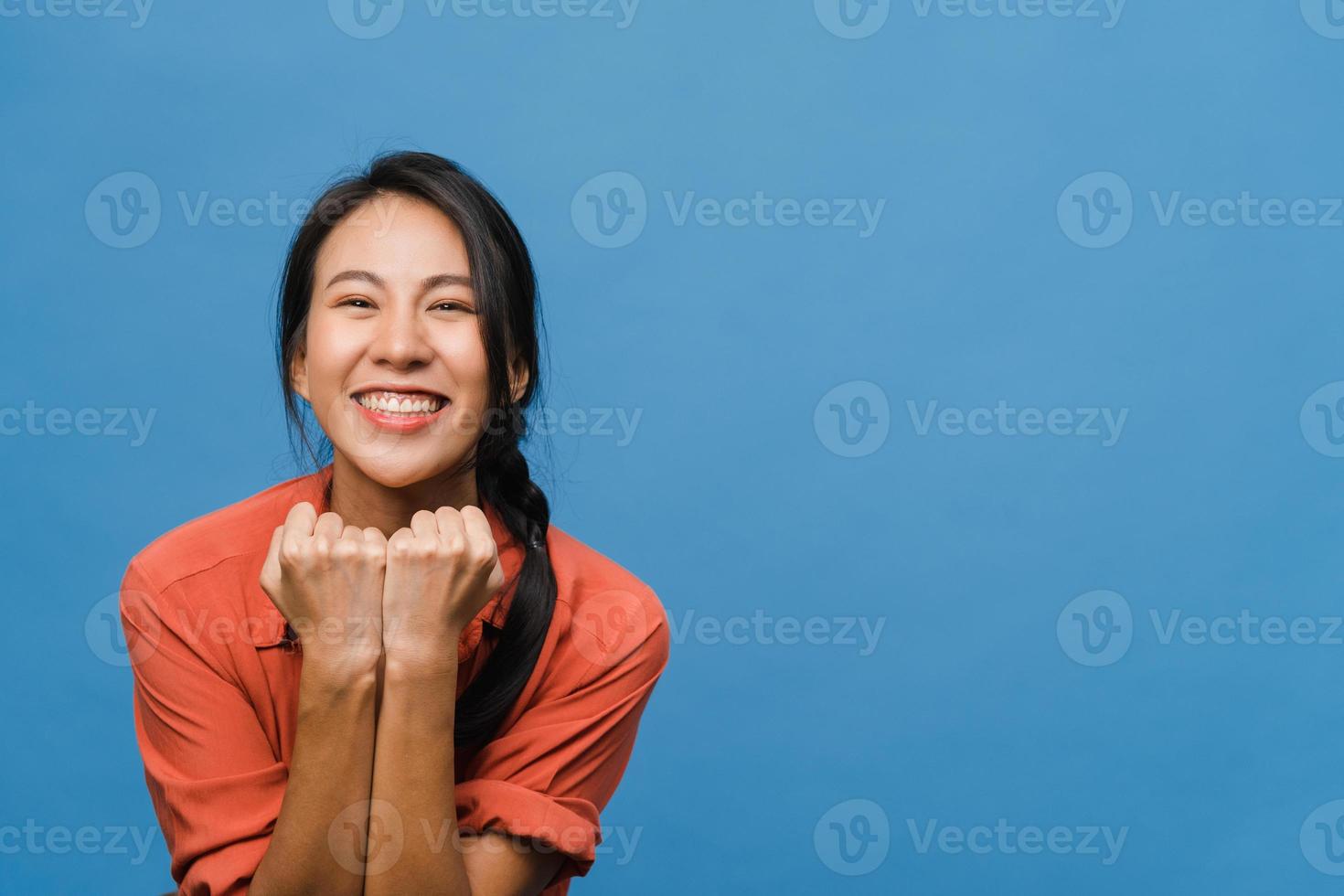 junge asiatische dame mit positivem ausdruck, fröhlich und aufregend, in lässigem tuch gekleidet und blick in die kamera auf blauem hintergrund. glückliche entzückende frohe frau freut sich über erfolg. Gesichtsausdruck Konzept. foto