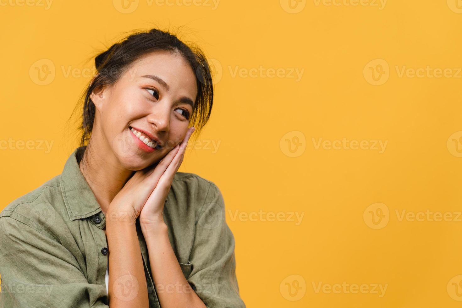 Porträt der jungen asiatischen Dame mit positivem Ausdruck, breit lächeln, in Freizeitkleidung auf gelbem Hintergrund gekleidet. glückliche entzückende frohe frau freut sich über erfolg. Gesichtsausdruck Konzept. foto