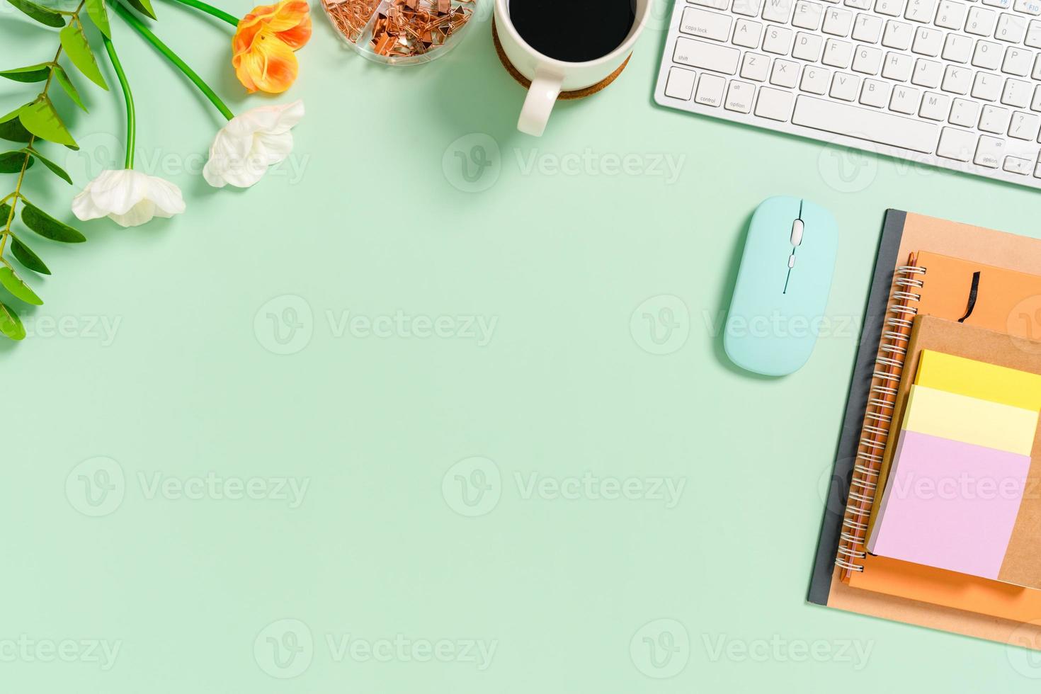 minimaler arbeitsplatz - kreatives flaches foto des arbeitsplatzes. Schreibtisch von oben mit Tastatur, Maus und Notebook auf pastellgrünem Hintergrund. Draufsicht mit Kopienraum, Flachfotografie.