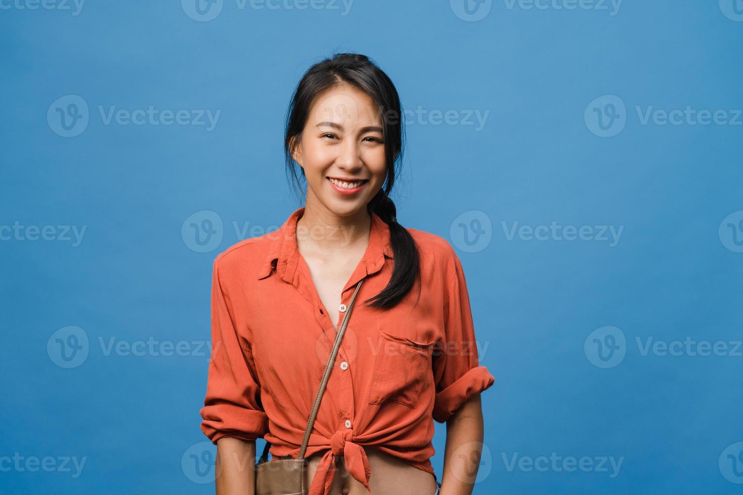 junge asiatische Dame mit positivem Ausdruck, breit lächeln, in Freizeitkleidung gekleidet und mit Blick auf die Kamera auf blauem Hintergrund. glückliche entzückende frohe frau freut sich über erfolg. Gesichtsausdruck Konzept. foto