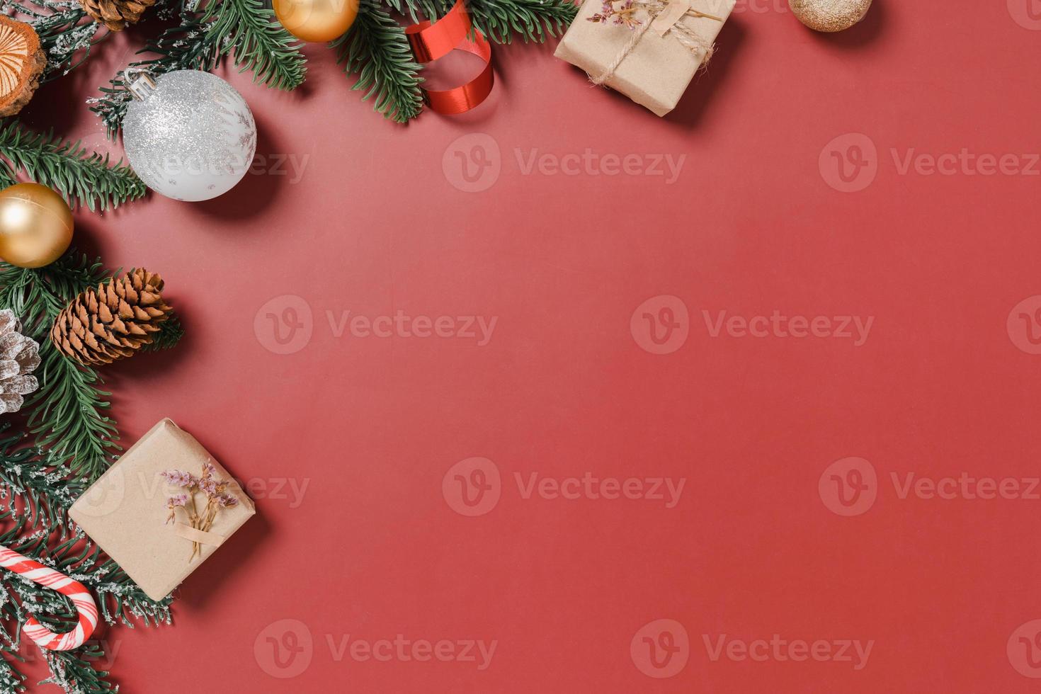 minimale kreative flache Lage von traditioneller Weihnachtskomposition und Neujahrsferienzeit. Draufsicht Winterweihnachtsdekorationen auf rotem Hintergrund mit Leerzeichen für Text. Raumfotografie kopieren. foto