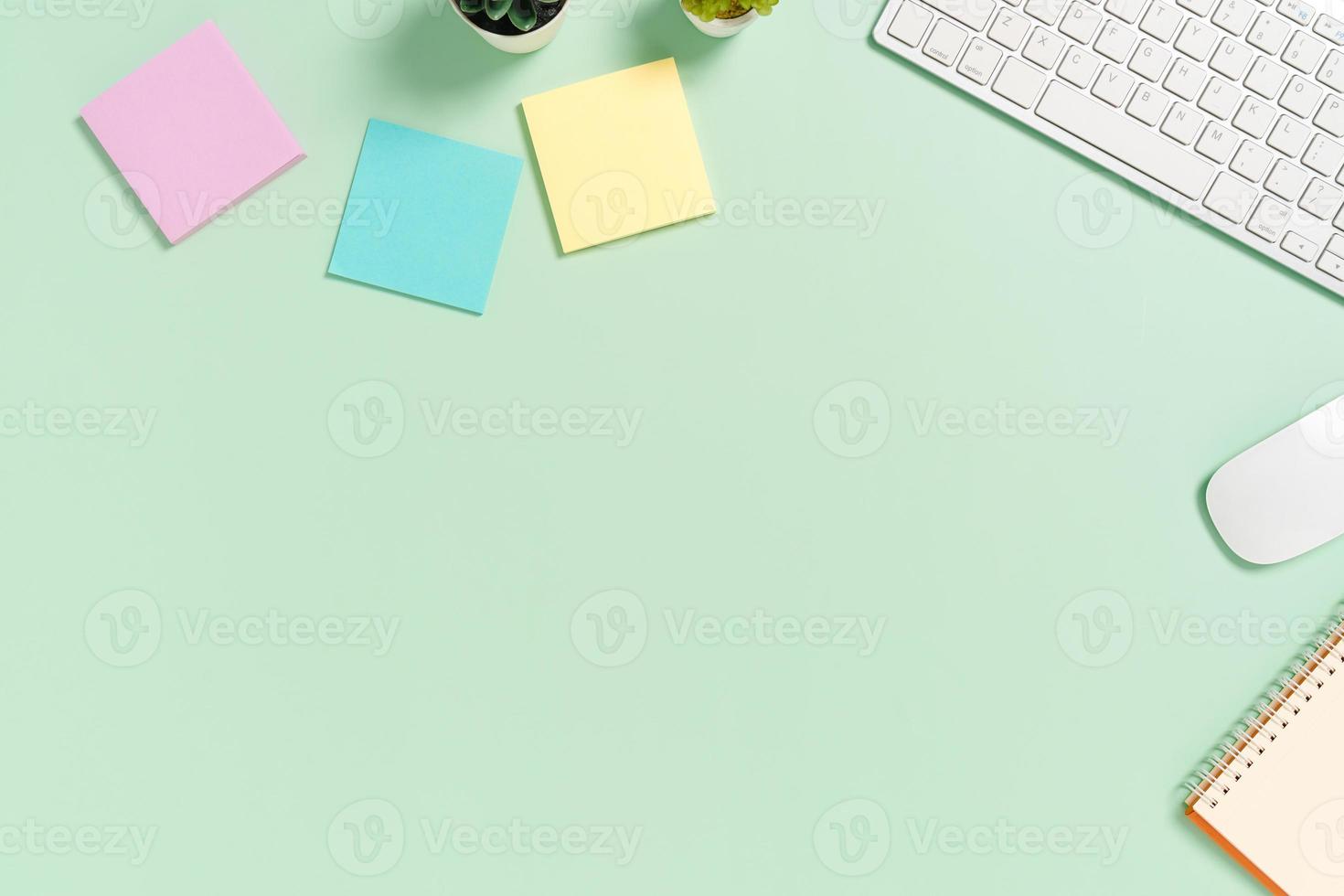 minimaler arbeitsplatz - kreatives flaches foto des arbeitsplatzes. Schreibtisch von oben mit Tastatur, Maus und Buch auf pastellgrünem Hintergrund. Draufsicht mit Kopienraum, Flachfotografie.