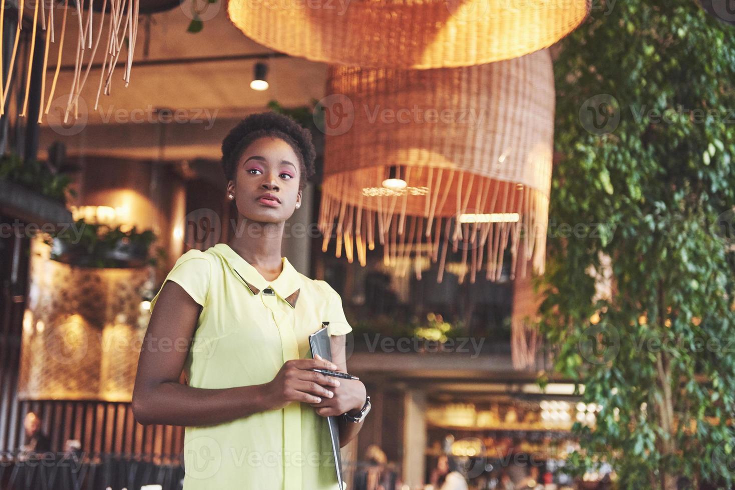 Afroamerikanische Geschäftsfrau steht mit einem Ordner in der Hand foto