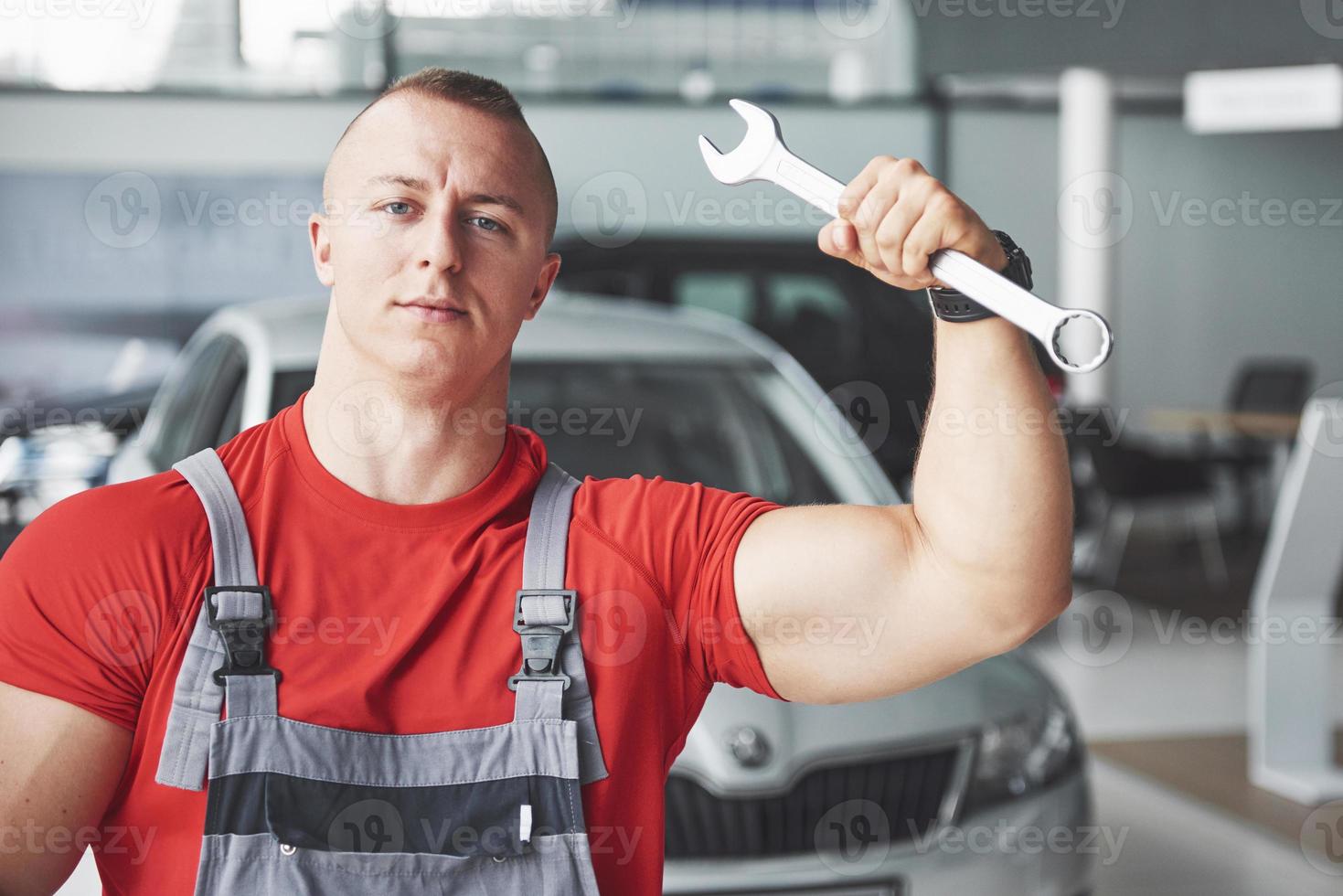 Hände des Automechanikers mit Schraubenschlüssel in der Garage foto