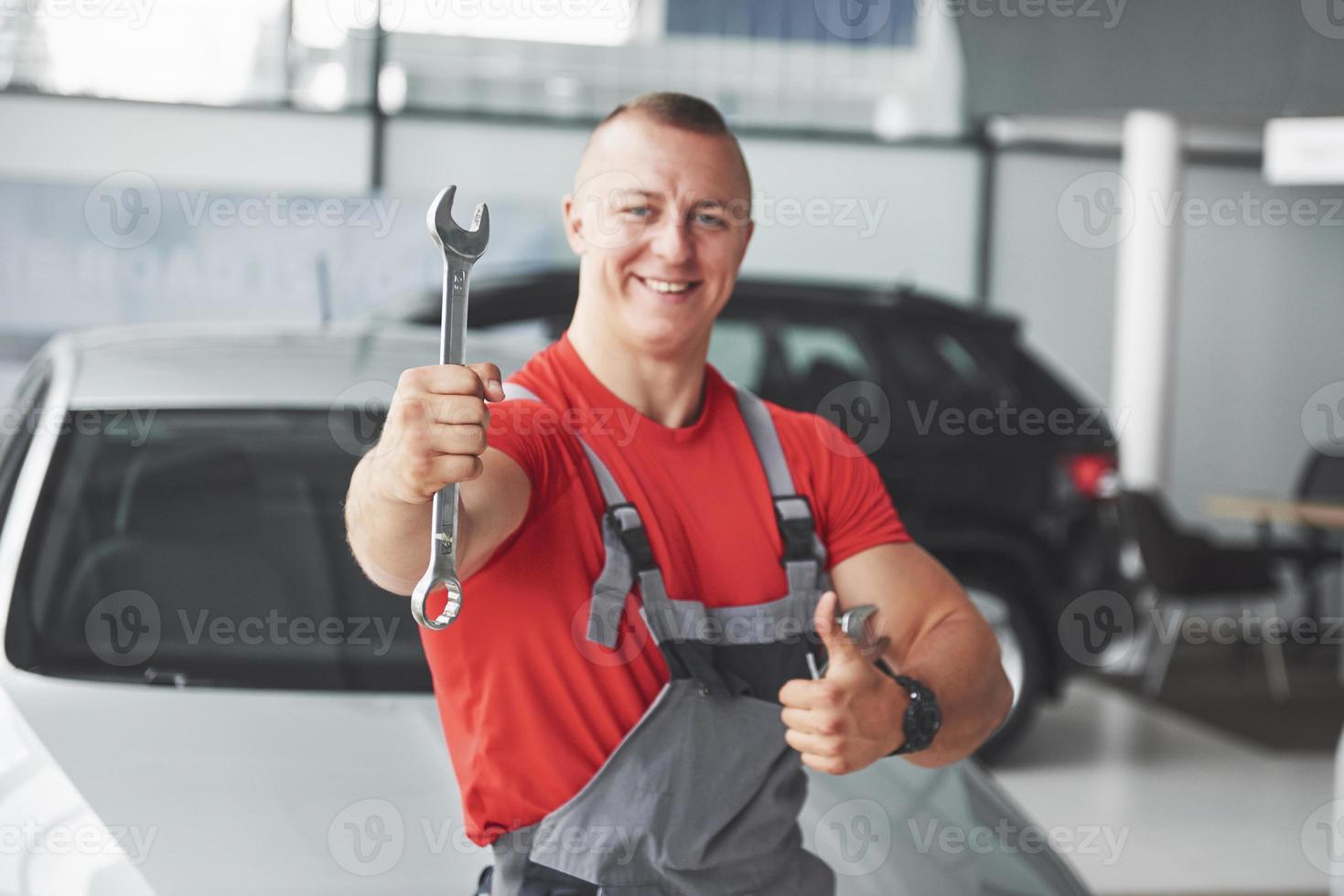 Hände des Automechanikers mit Schraubenschlüssel in der Garage foto