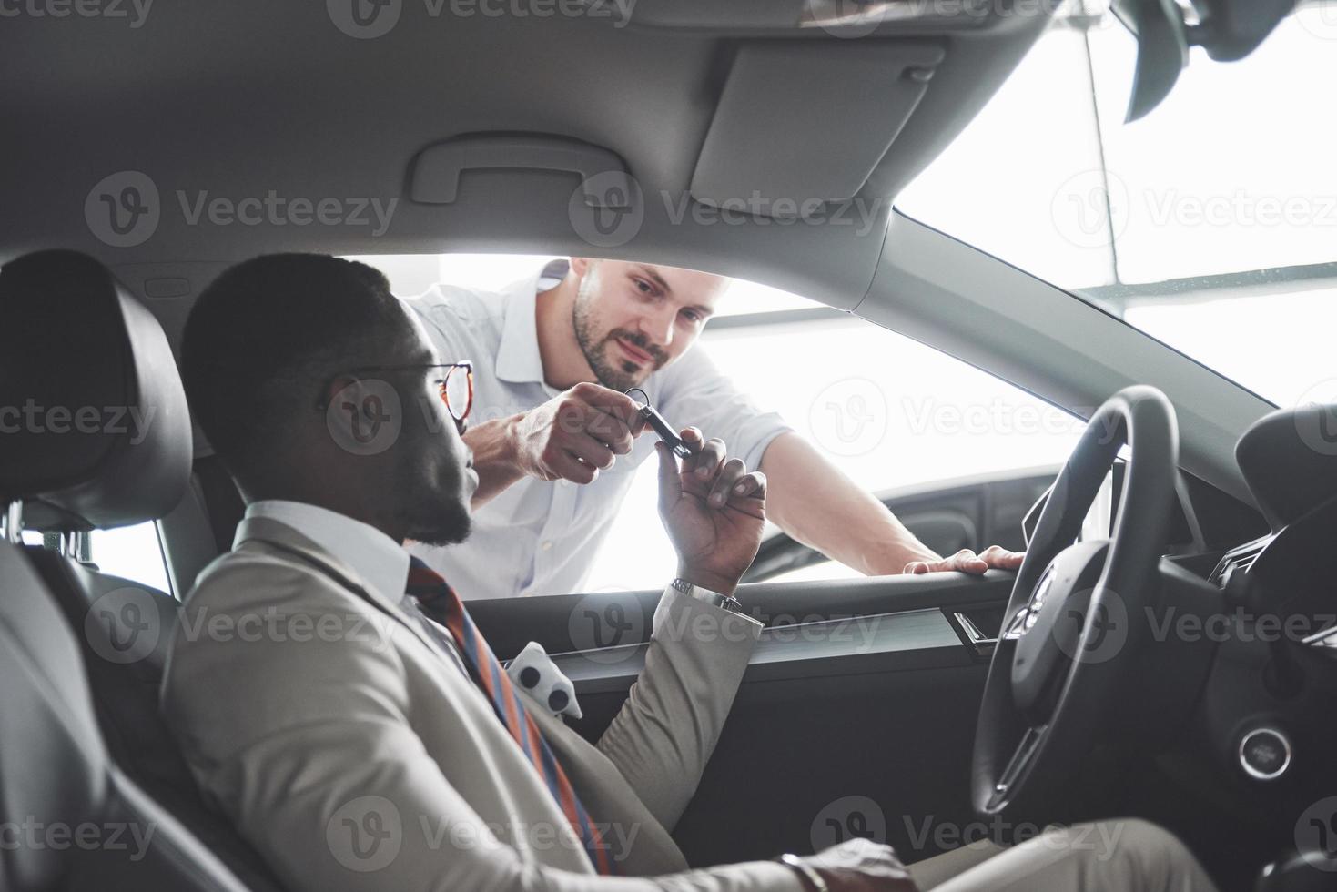 junger schwarzer Geschäftsmann Probefahrt neues Auto. reicher afroamerikanischer Mann foto