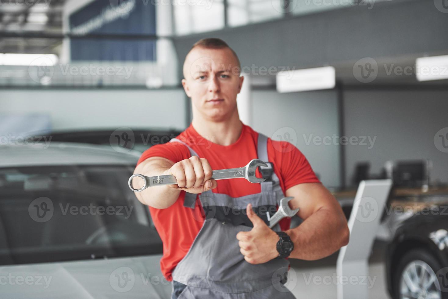 Hände des Automechanikers mit Schraubenschlüssel in der Garage foto