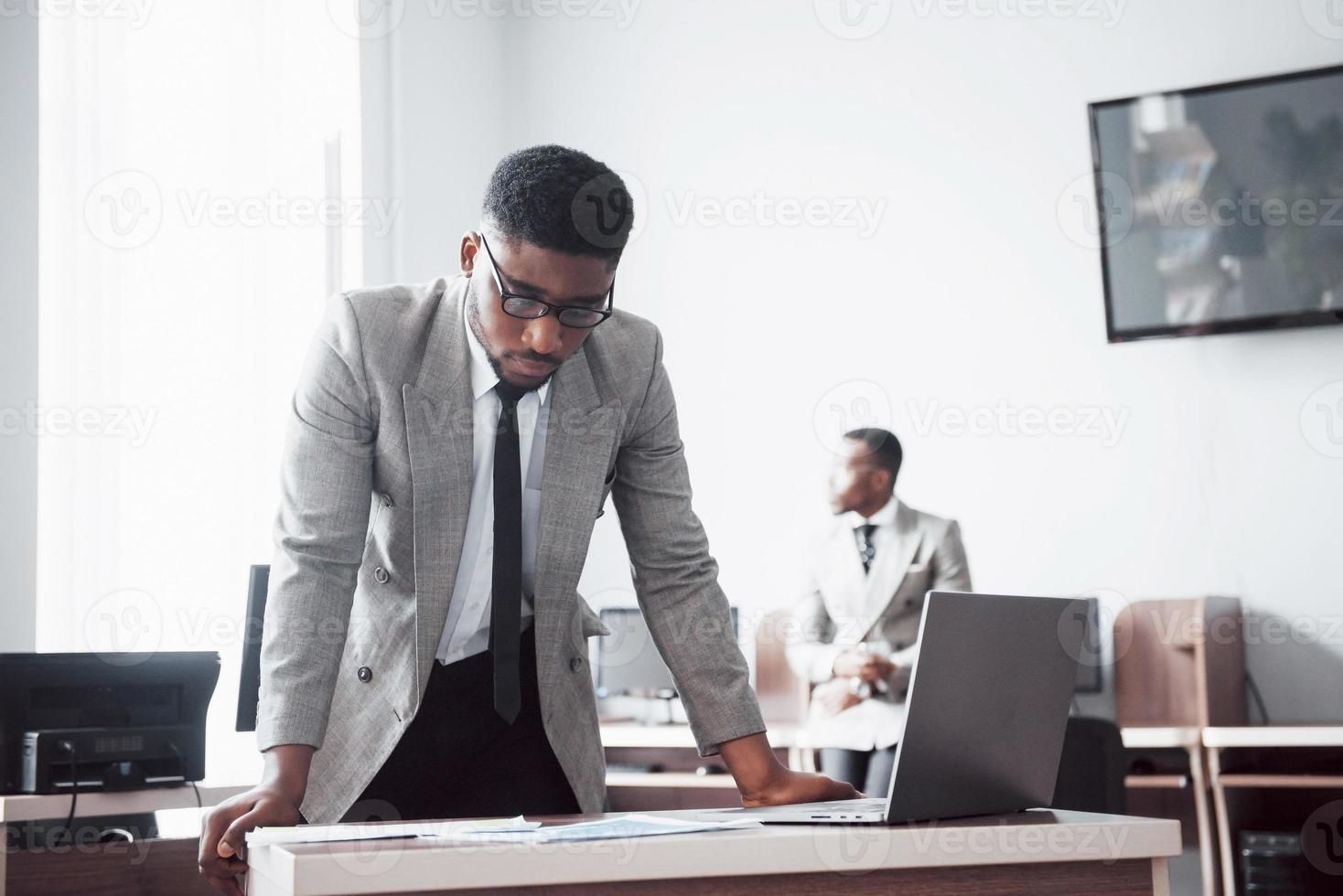 zwei gutaussehende, fröhliche afroamerikanische geschäftsleute im arbeitsbereich büro foto