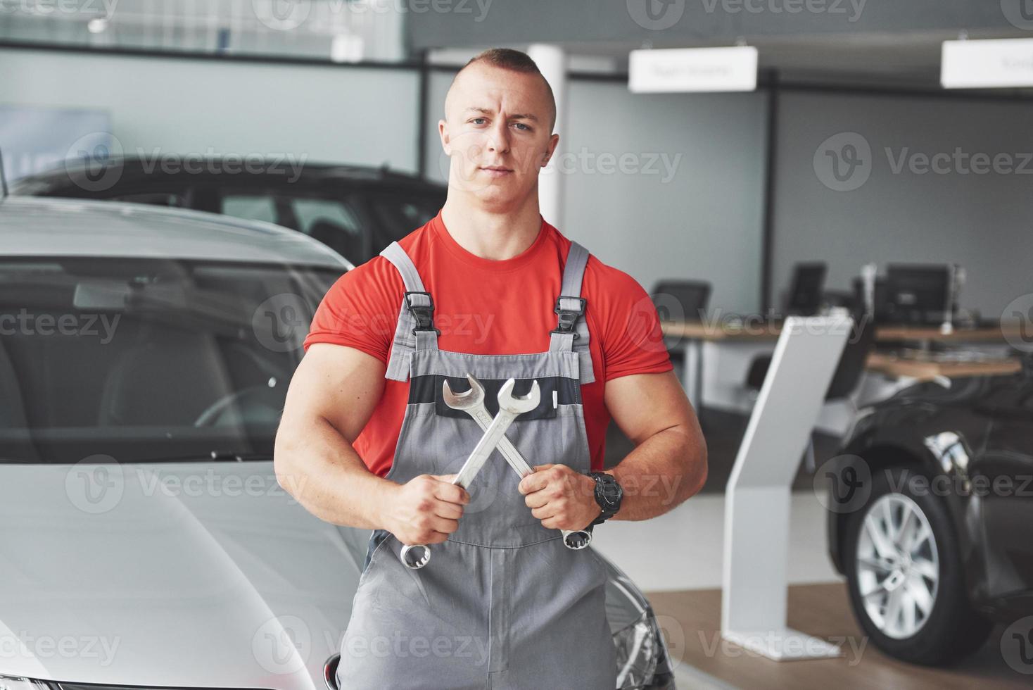 Hände des Automechanikers mit Schraubenschlüssel in der Garage foto