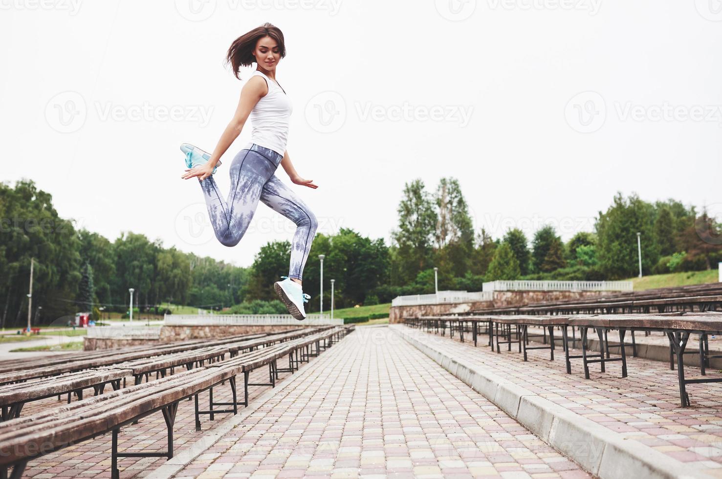 Frau macht Parkour in der Stadt an einem sonnigen Tag foto