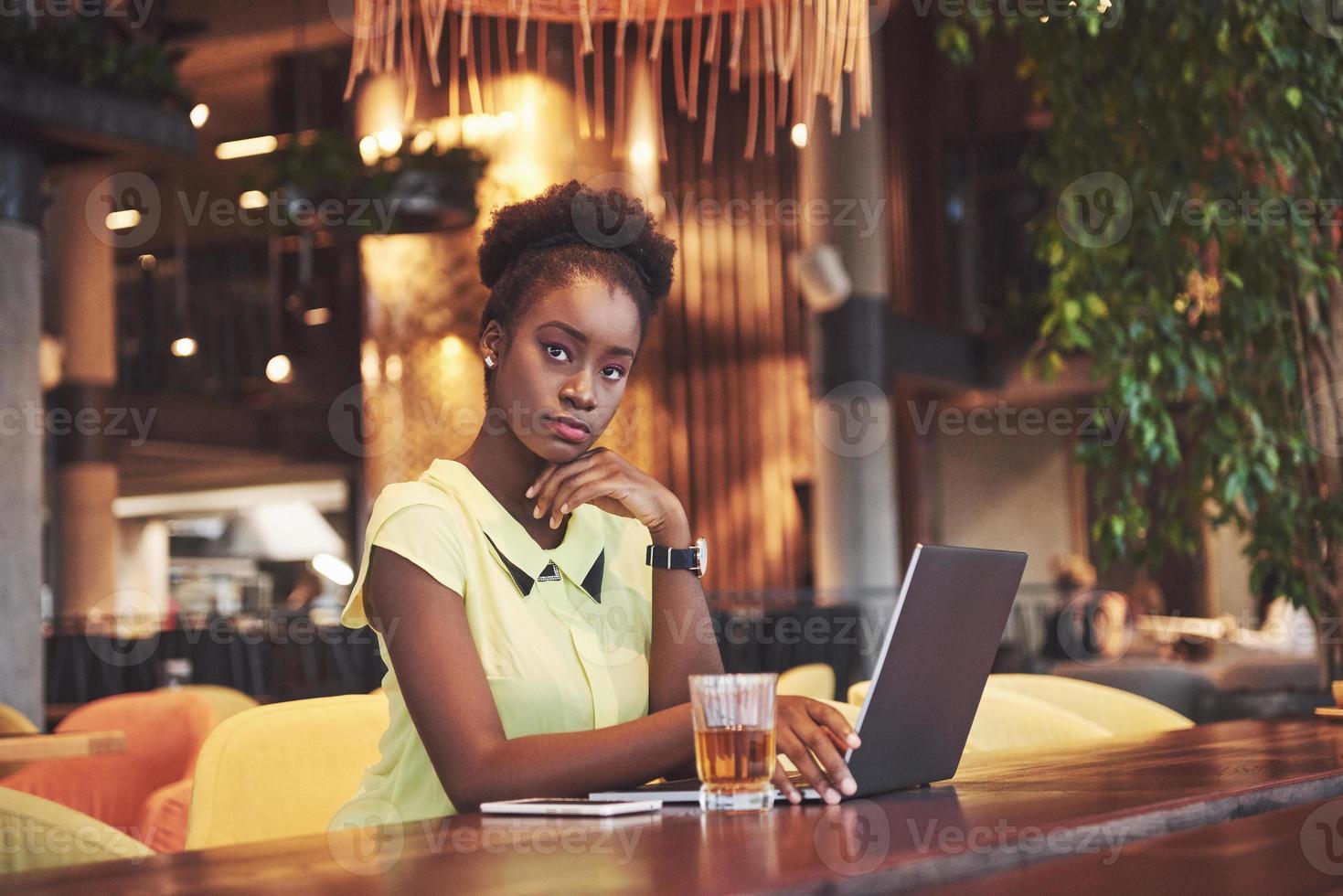 schöne junge Frau sitzt in einem Café und arbeitet an einem Laptop foto