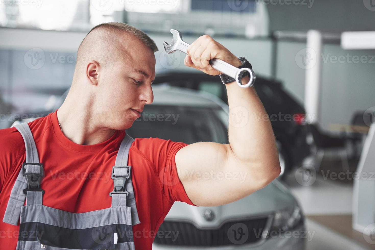 Hände des Automechanikers mit Schraubenschlüssel in der Garage foto