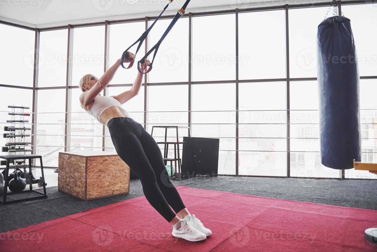 Frauen, die Liegestütze machen, trainieren Arme mit Trx-Fitnessgurten im Fitnessstudio-Konzept, trainieren gesunder Lebensstil Sport foto