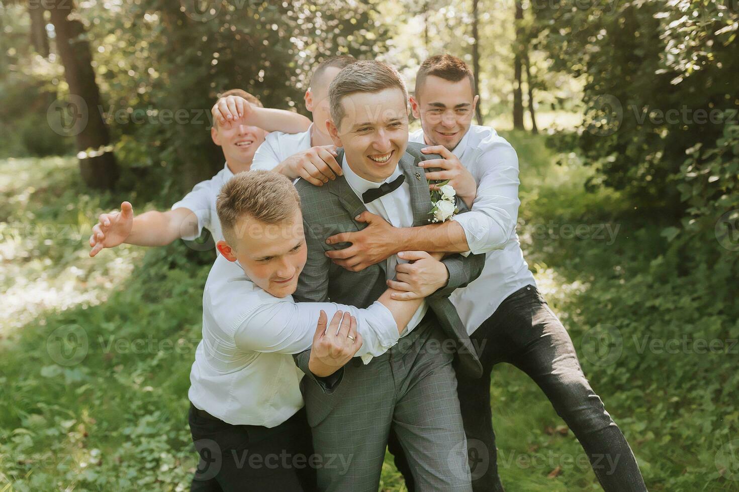 das Bräutigam feiert seine Hochzeit mit freunde draußen nach das Zeremonie foto