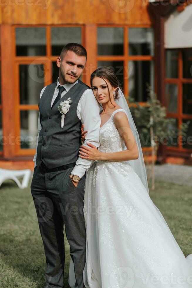 ein schön Hochzeit, ein schön Paar im Liebe, Lachen und küssen gegen das Hintergrund von ein Grün Garten. hoch Qualität Foto