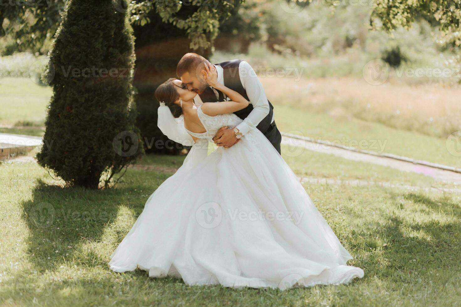 ein schön Hochzeit, ein schön Paar im Liebe, Lachen und küssen gegen das Hintergrund von ein Grün Garten. hoch Qualität Foto