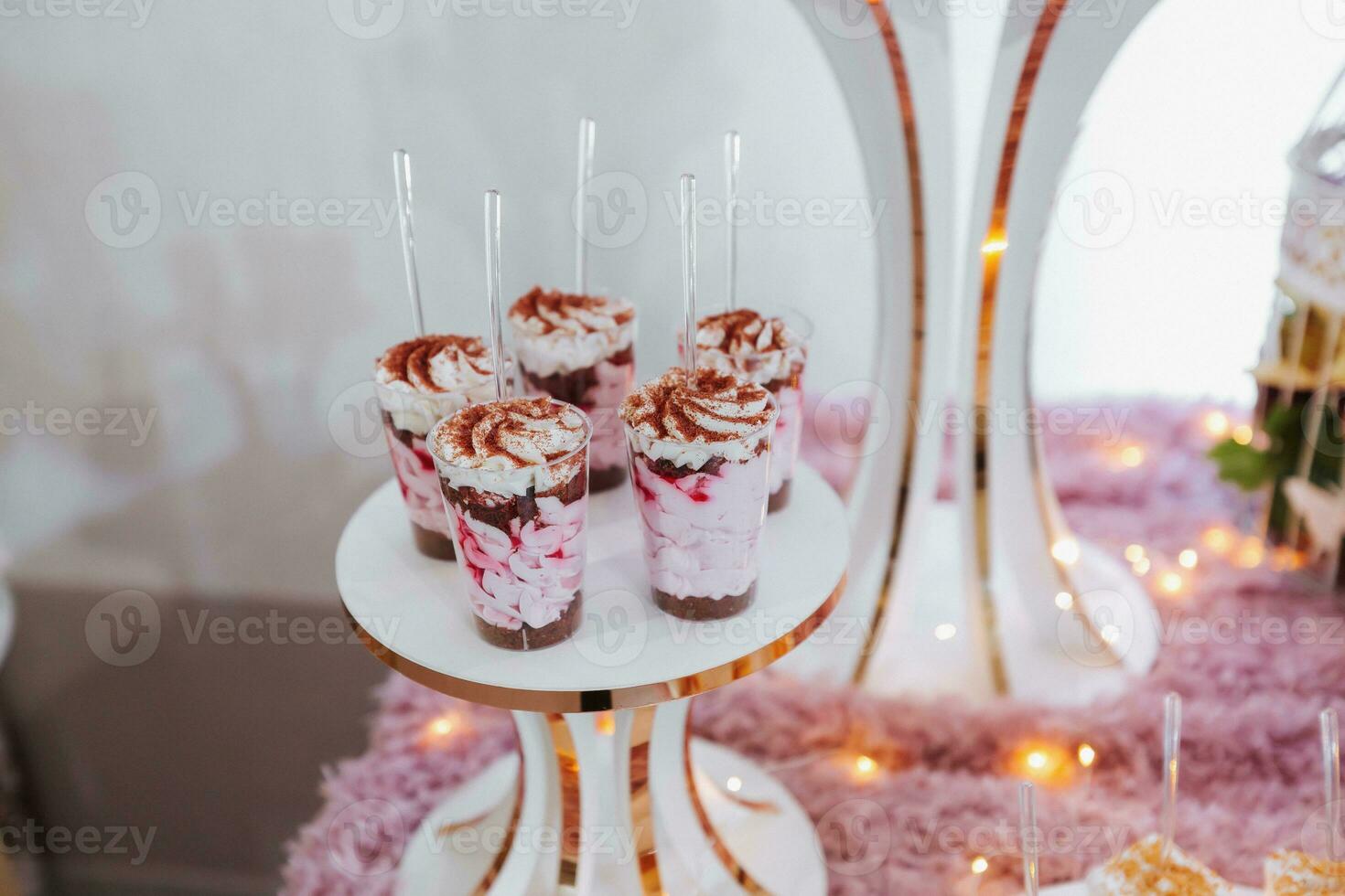 festlich Dessert Tabelle mit Süßigkeiten. Hochzeit Süßigkeiten Bar, verschiedene Kuchen, Pralinen auf steht. foto