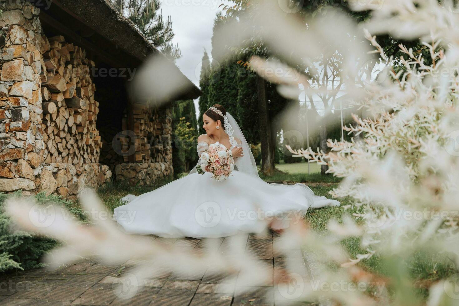 Porträt von ein schön Braut im ein Weiß Hochzeit Kleid mit ein lange Zug mit ein modern Frisur und ein Schleier Gehen im das Garten. Hochzeit Konzept foto