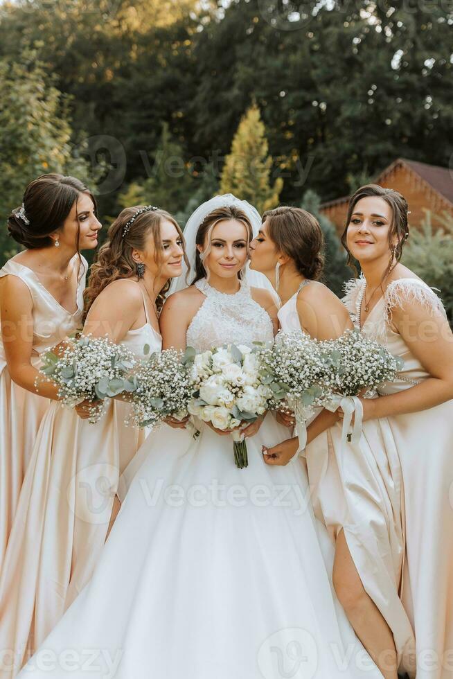 ein Gruppe von schön Frauen im passend Kleider sind lächelnd, Feiern, und haben Spaß zusammen. freunde von das Braut im Rosa Kleider feiern das Hochzeit zusammen mit das Braut foto
