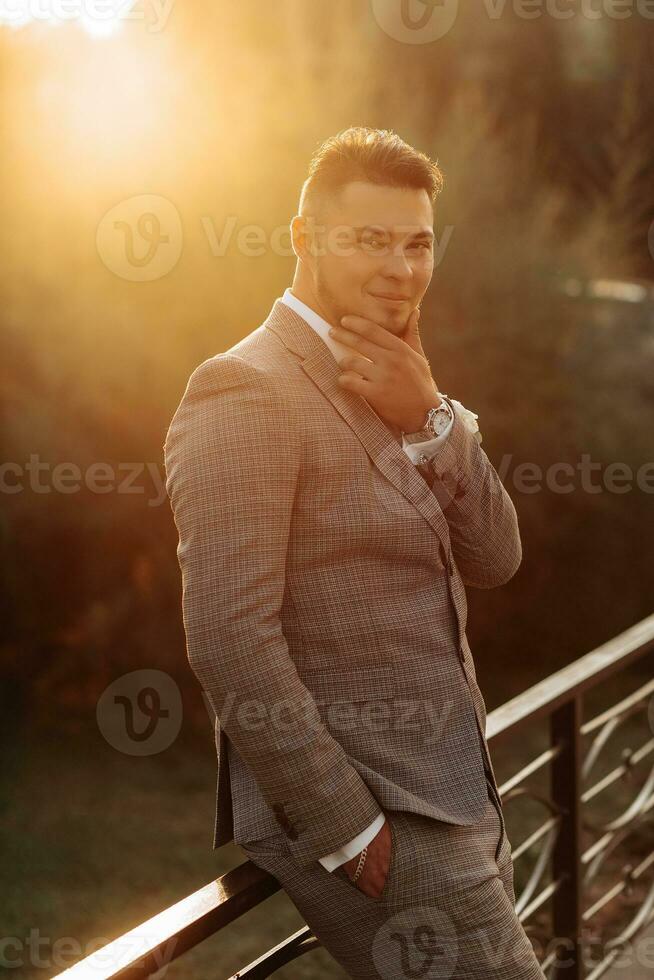 gut aussehend bärtig Mann, Bräutigam im grau passen und schwarz Krawatte Stehen draußen. Hochzeit Porträt. ein Mann im ein klassisch passen foto