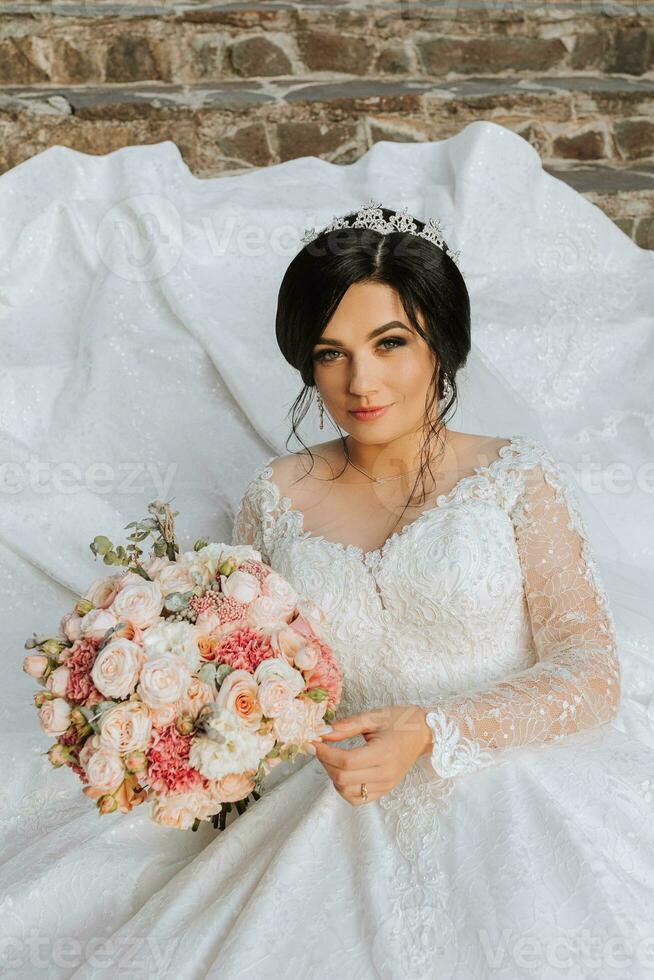 ein schön Braut im ein schick Hochzeit Kleid steht auf uralt Schritte im das Park foto