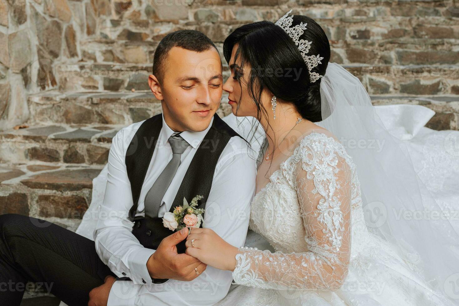 ein schön Braut im ein schick Hochzeit Kleid und ein elegant Bräutigam Stand auf uralt Schritte im das Park foto