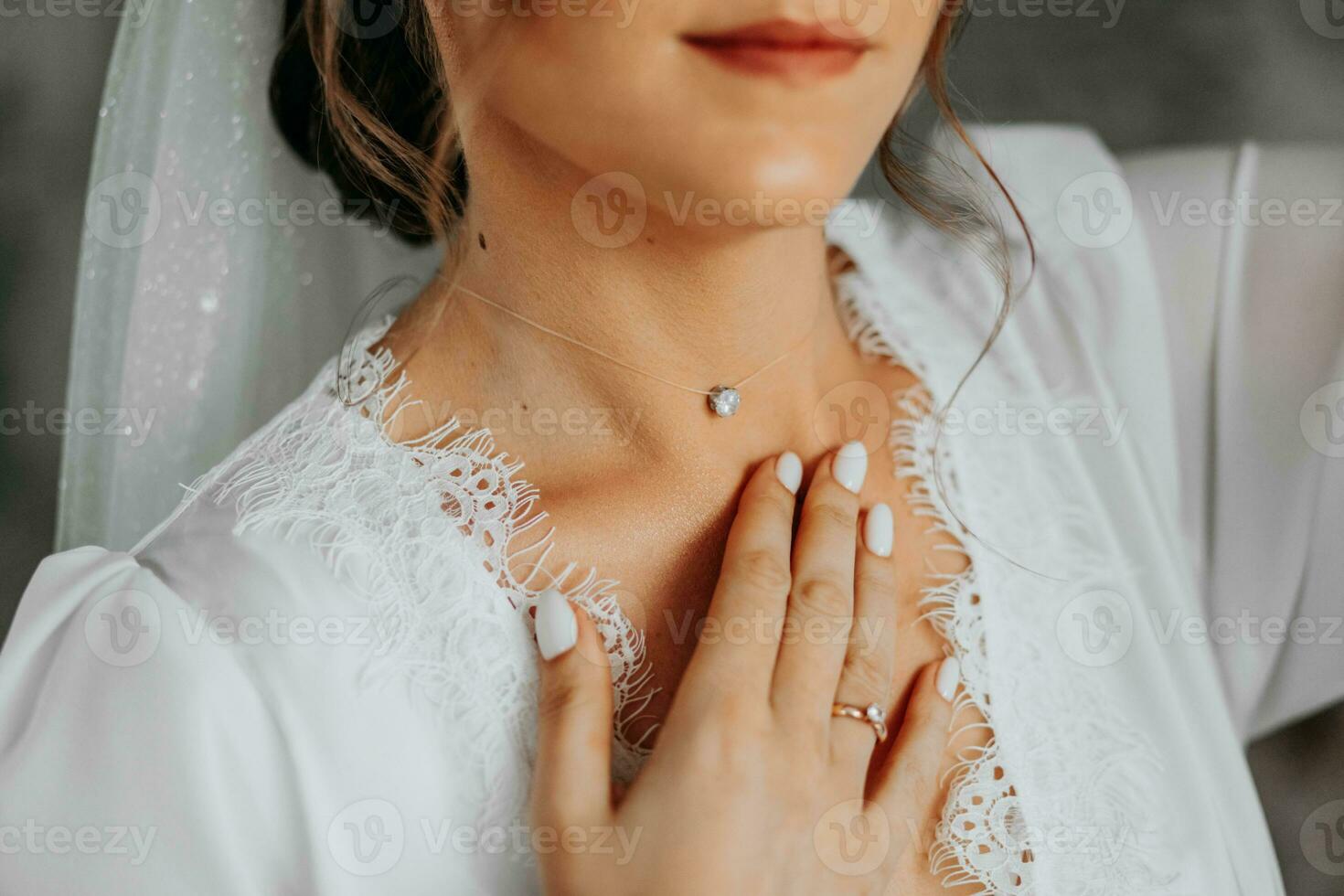 Morgen Vorbereitung von das Braut. Halskette auf das Nacken. ein Anhänger auf ein Frau Nacken. das Mädchen sanft berührt das Anhänger auf ihr Hals mit ihr Finger. oben schließen Französisch Maniküre foto