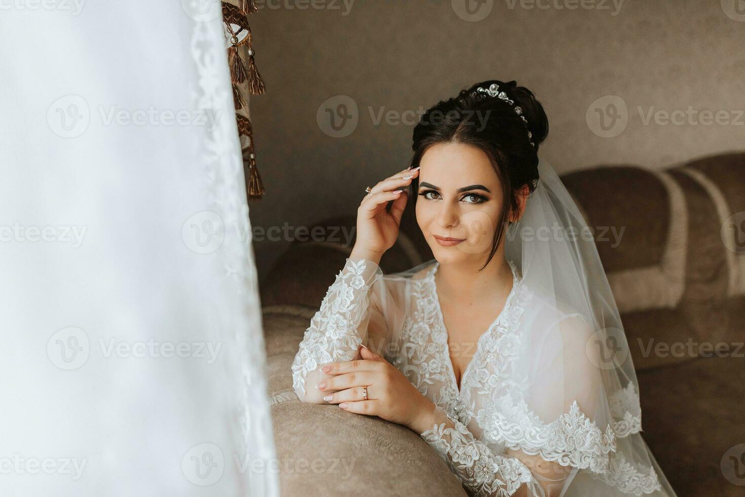 Porträt von das Braut mit Studio Licht im ihr Zimmer. großartig Haar und bilden. Morgen von das Braut. Vorbereitung zum das Hochzeit Zeremonie foto