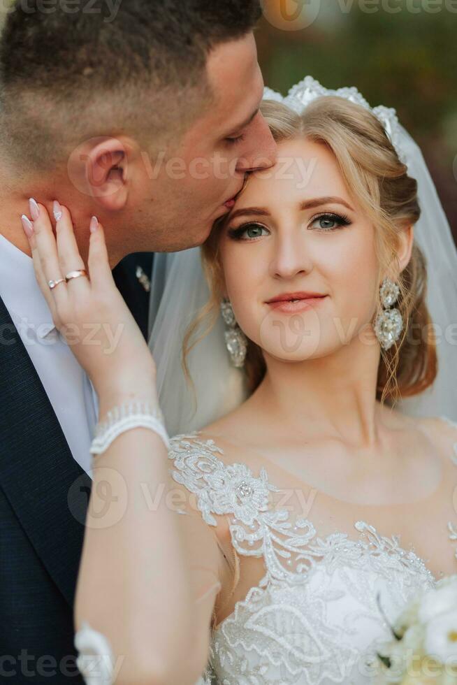 Porträt von ein elegant Hochzeit Paar zärtlich Umarmen im ein Wald oder Park. Luxus Braut und Bräutigam umarmen. romantisch sinnlich Moment foto