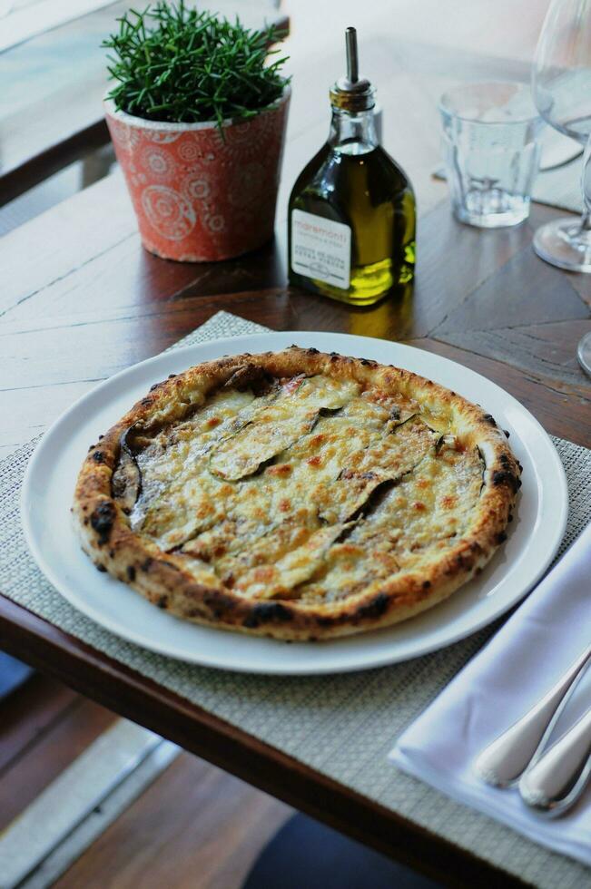 Pizza mit Käse und Olive Öl auf ein Tabelle im ein Restaurant foto