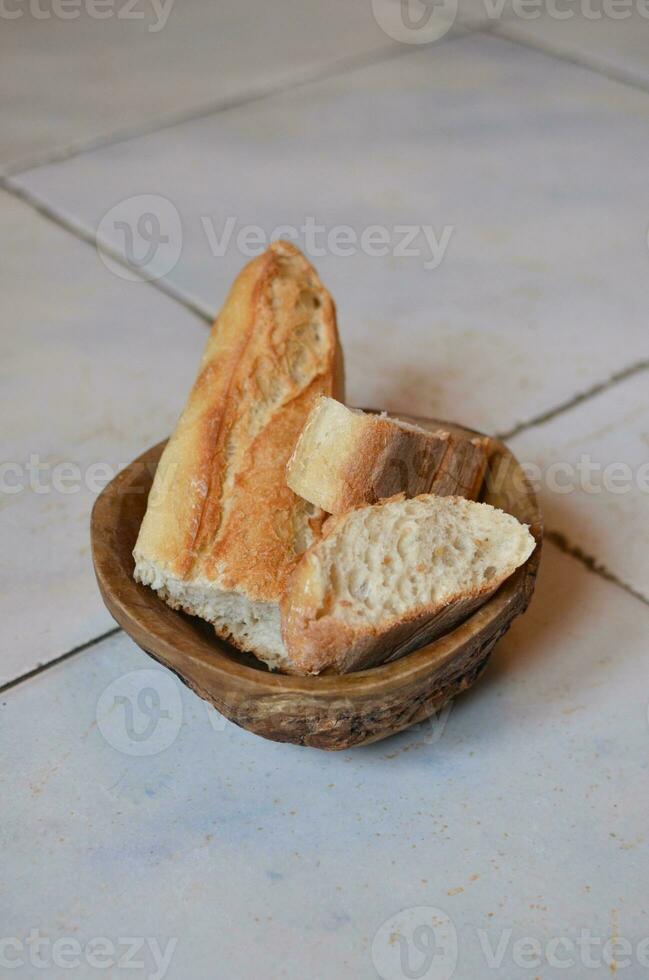 Brot im ein hölzern Schüssel auf das gefliest Boden, Thailand. foto