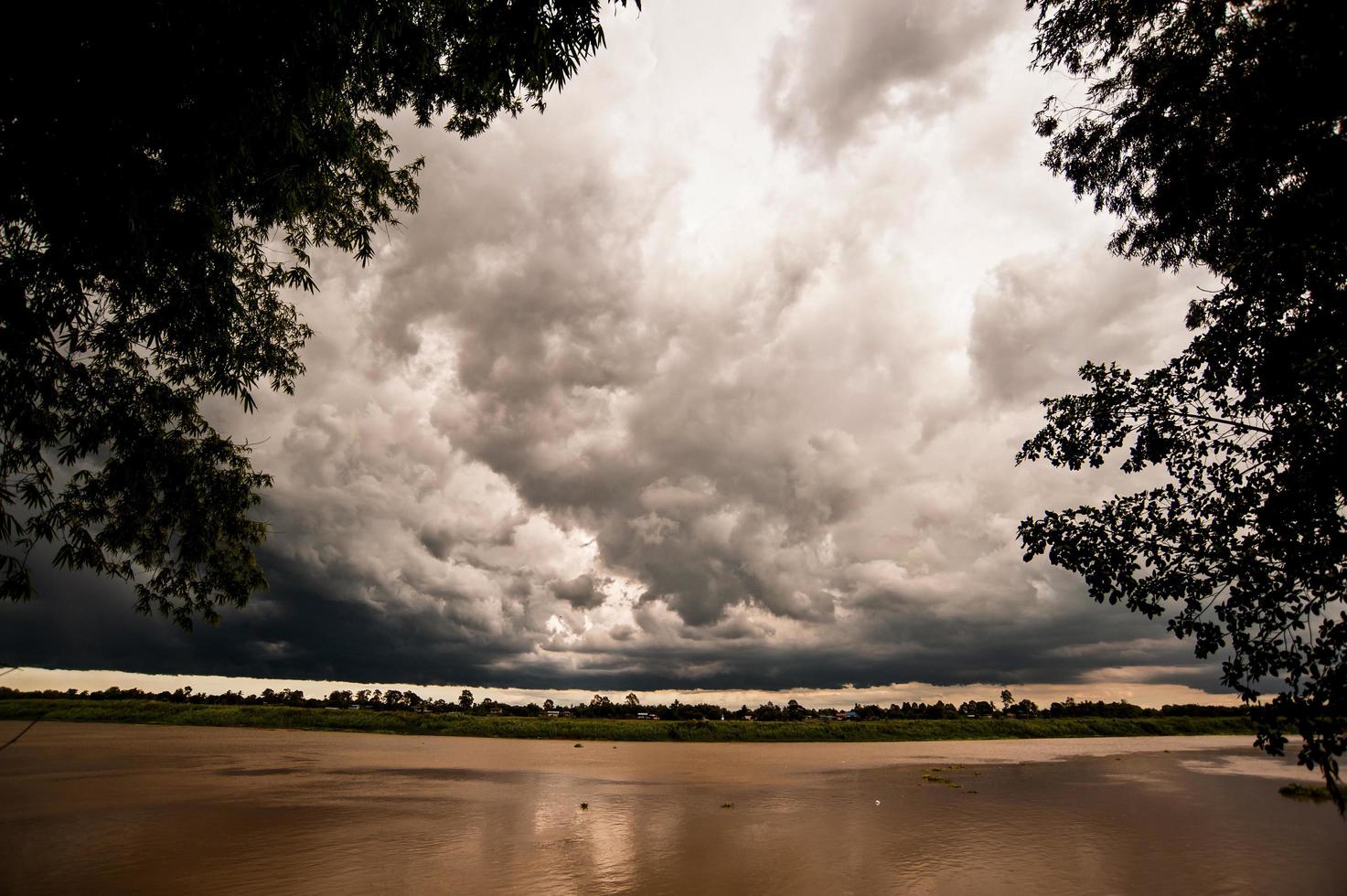 die schöne Wolkenhimmellandschaft mit Fluss und Bäumen in der Dämmerung foto