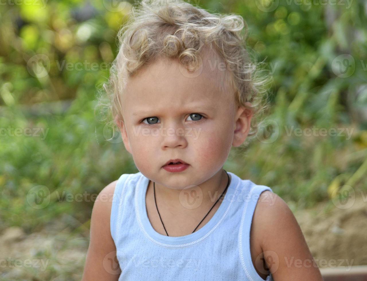 schönes Baby mit Kindergesicht posiert Fotograf für Farbfoto foto