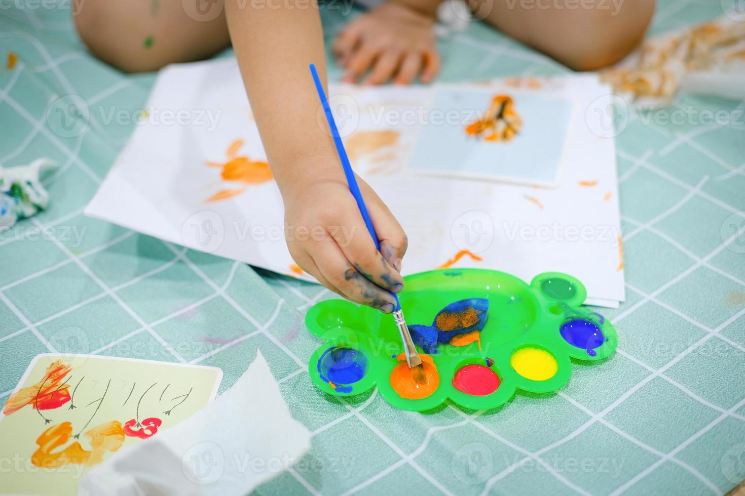 Kinder verwenden Aquarellpinsel, um ihre Fantasie zu wecken und ihre Lernfähigkeiten zu verbessern. foto