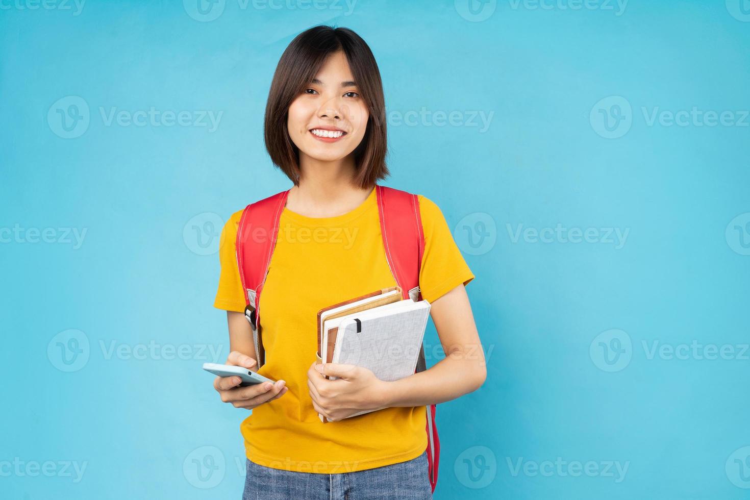Porträt der jungen Studentin, isoliert auf blauem Hintergrund foto