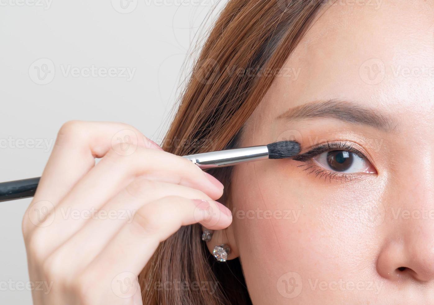 Porträt schöne Frau mit Make-up-Augenpinsel foto