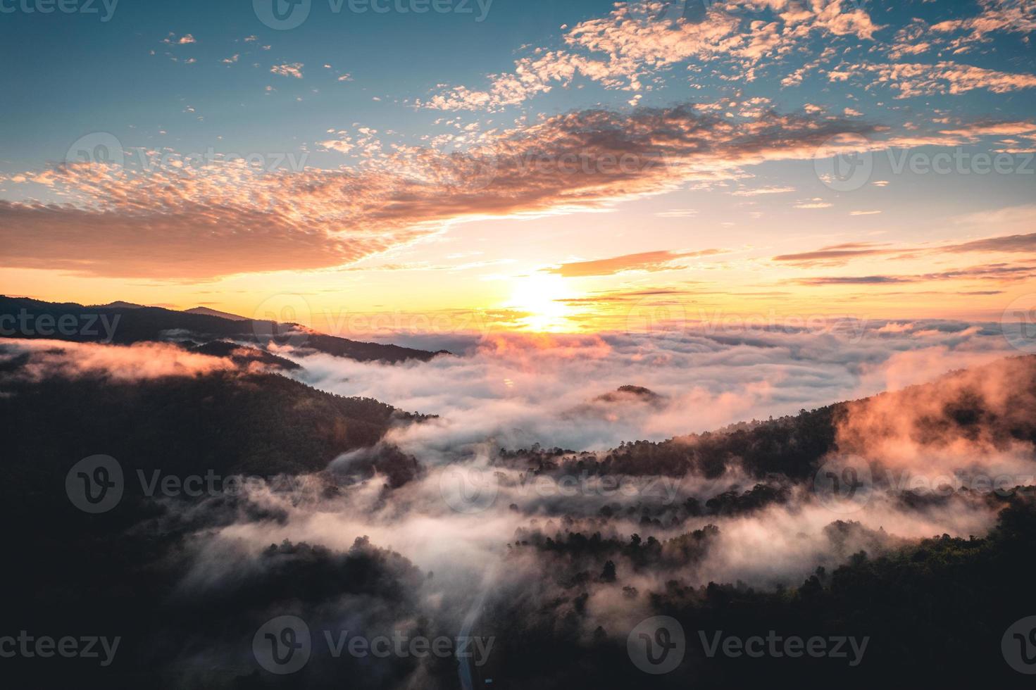 die Sonne geht im Nebel auf und die Berge am Morgen foto