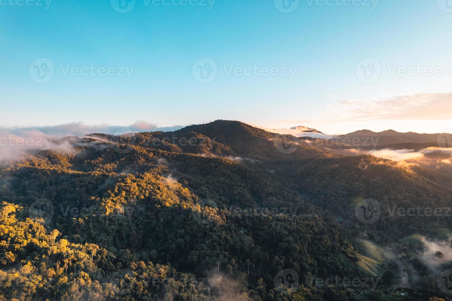 die Sonne geht im Nebel auf und die Berge am Morgen foto