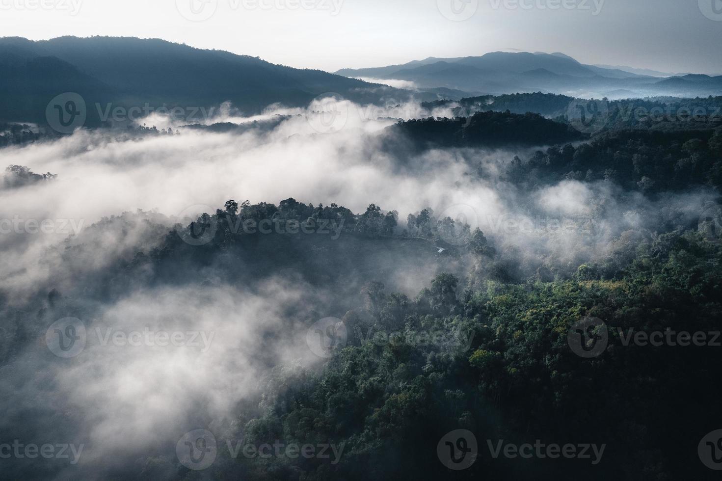 die Sonne geht im Nebel auf und die Berge am Morgen foto